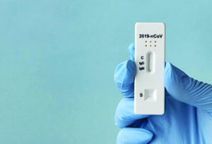 hand-with-protective-gloves-holding-covid-test